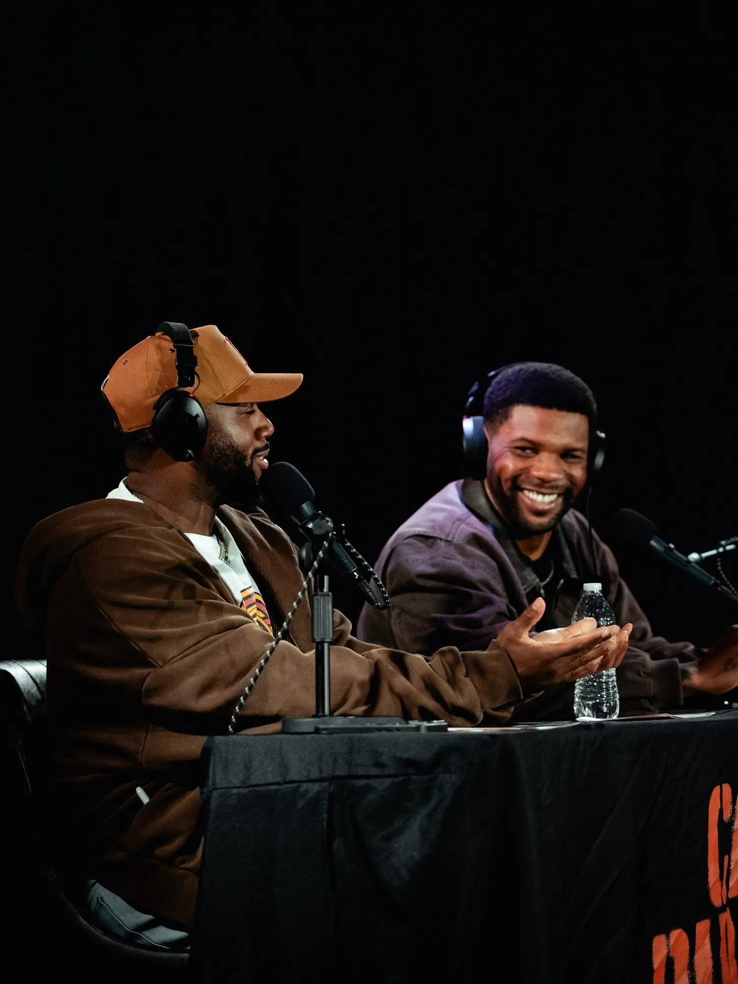 Mike and Pat in headphones, laughing at the desk