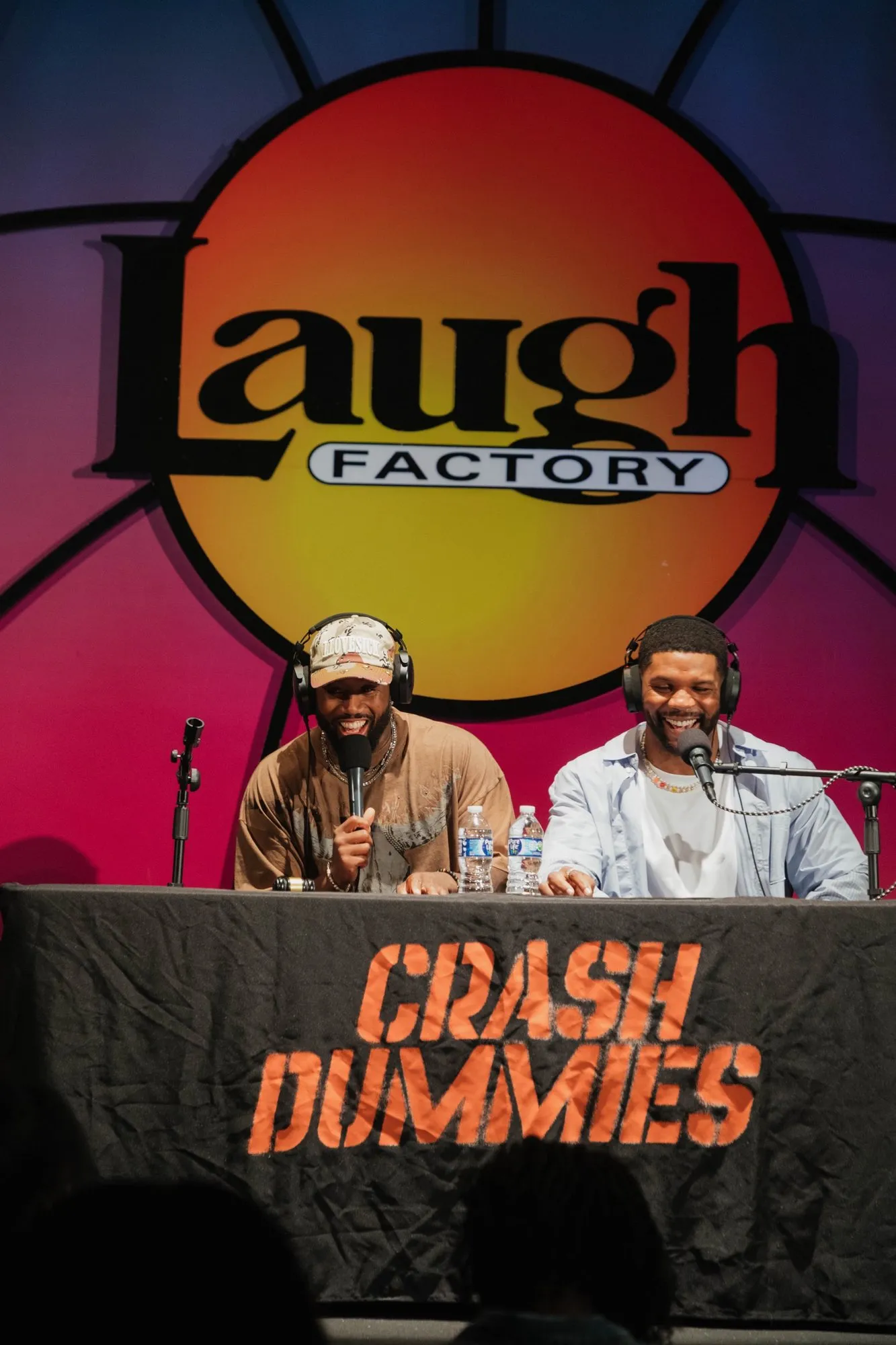 Mike and Pat at the desk under the Laugh Factory sign