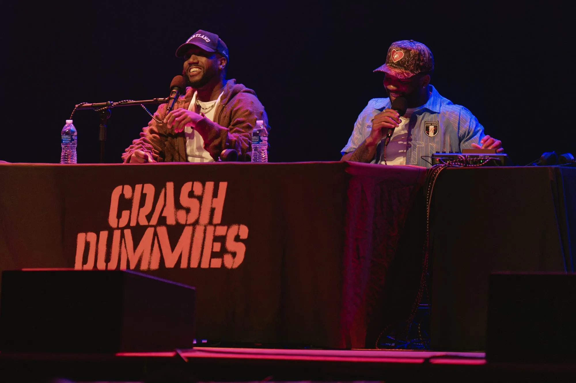 Both hosts laughing at the desk mid-show