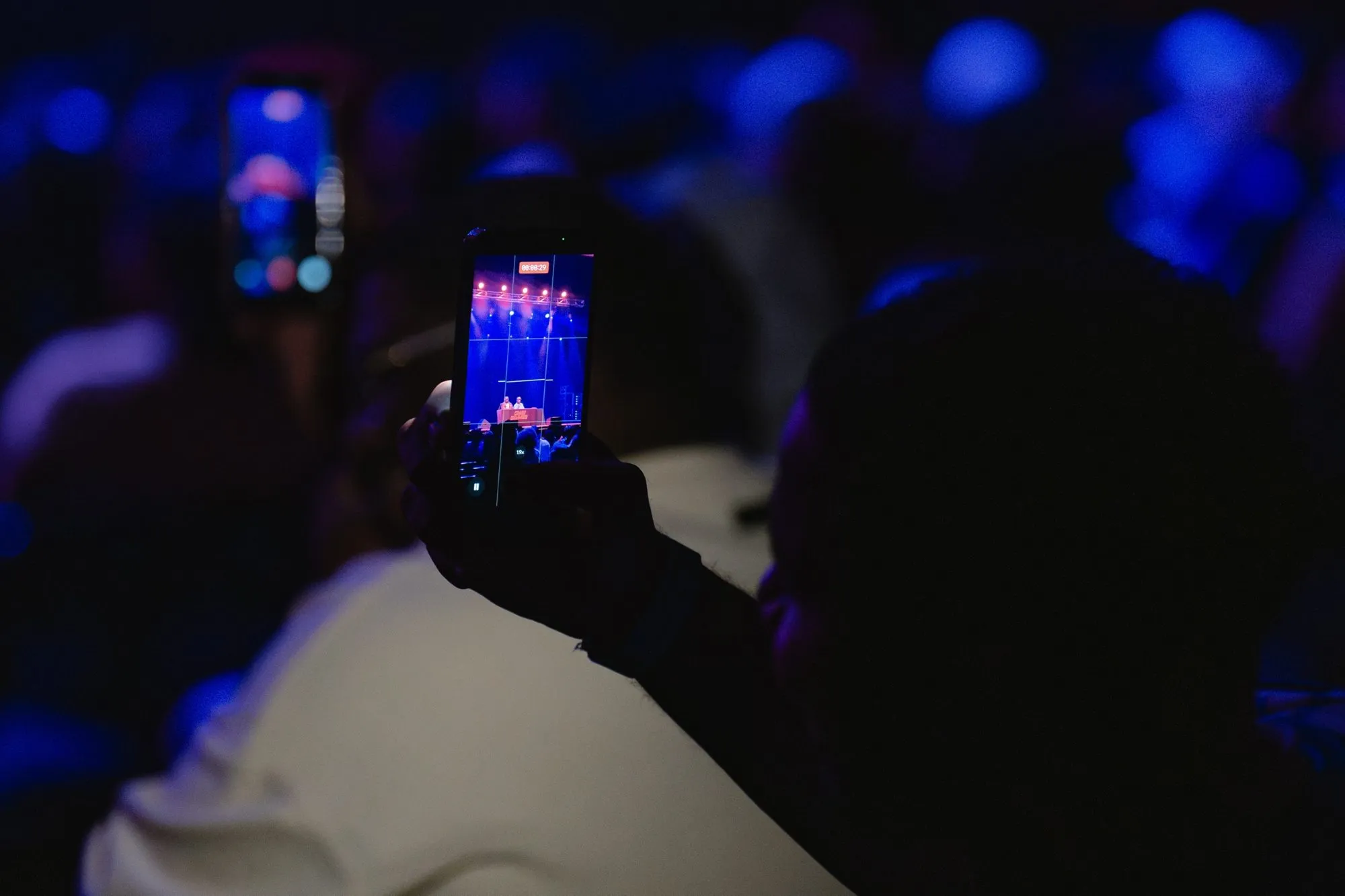 A fan films the stage on their phone