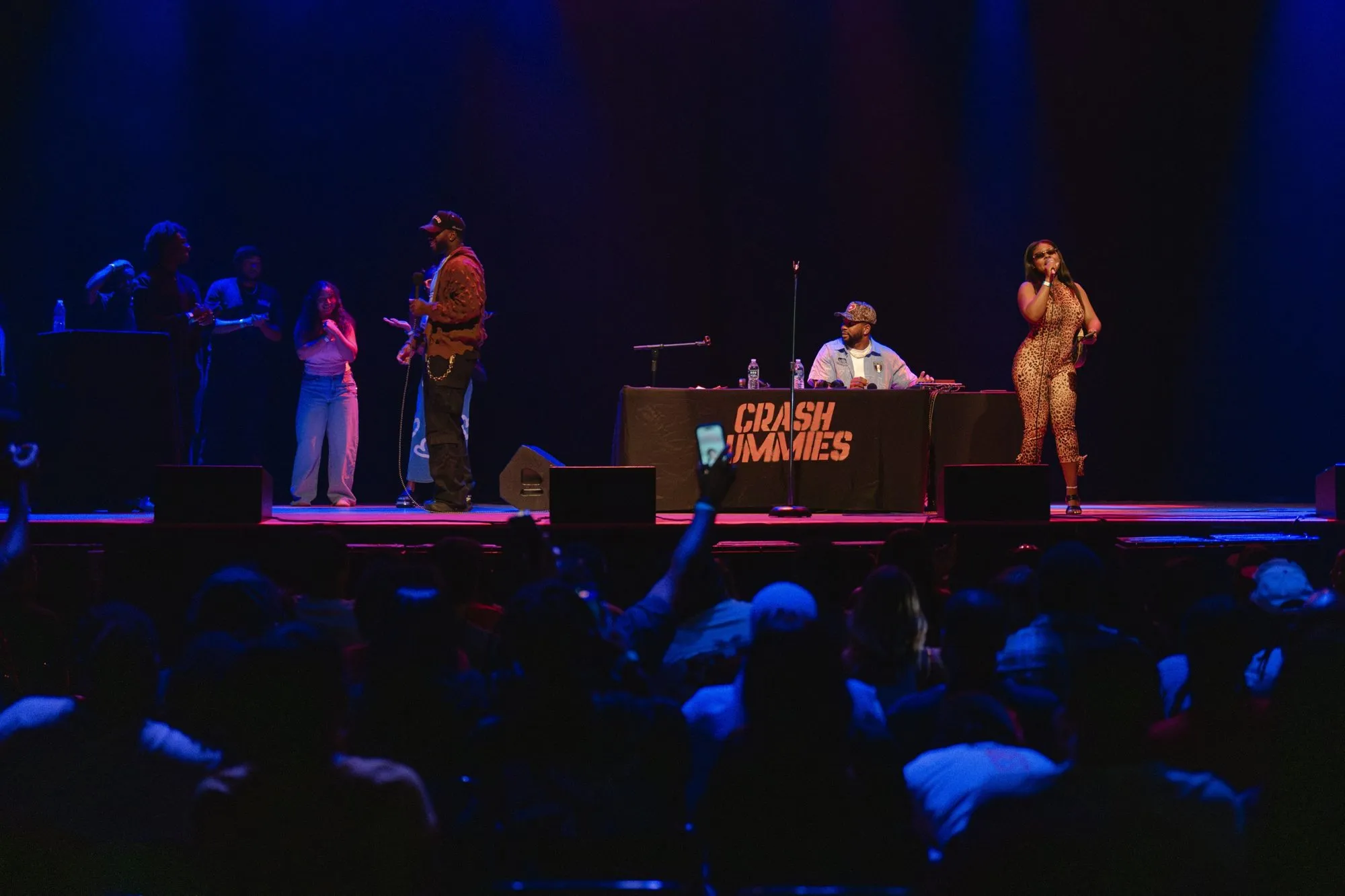 Wide shot of fans on stage as the crowd cheers