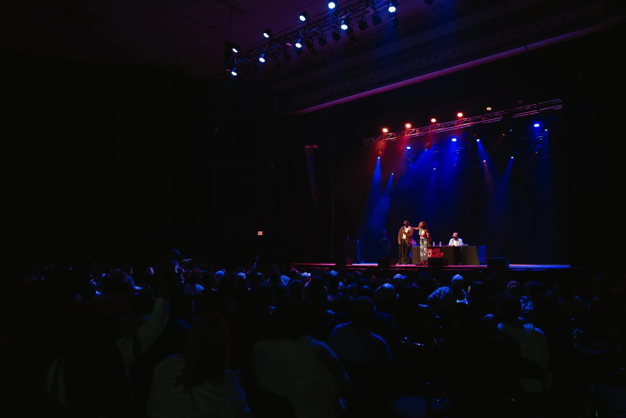 A fan on stage with a host while the crowd watches